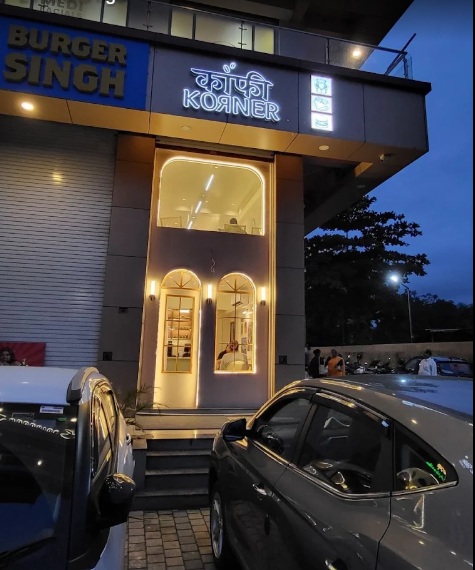 Genuine illuminated entrance and storefront of Kaaafi Korner in Silvassa at dusk
